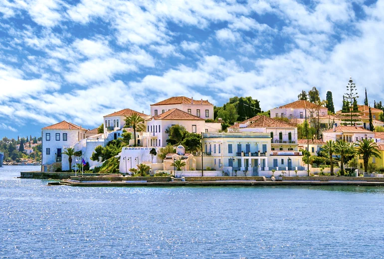 Catamaran sailing past a Greek island in light wind