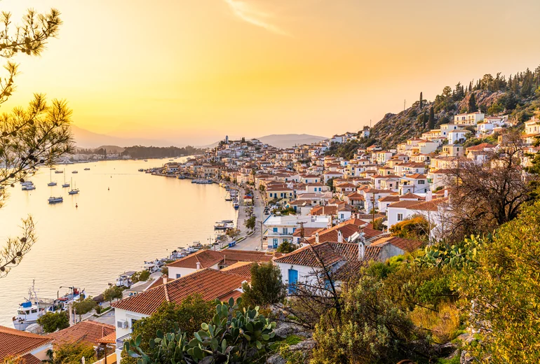 Pastel neoclassical harbour town in the Greek Dodecanese with boats moored stern-to
